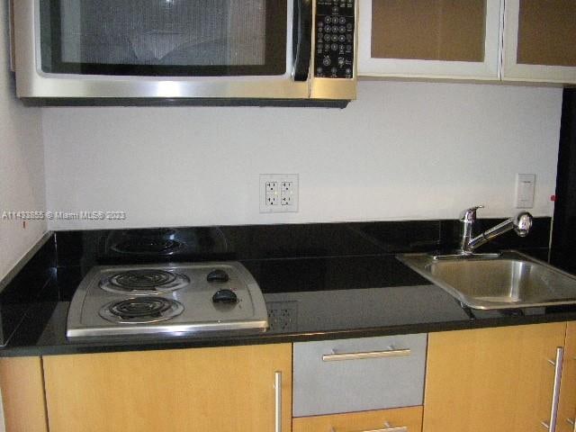 kitchen with light brown cabinets, electric cooktop, and sink