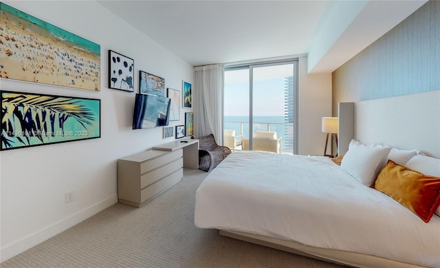 bedroom with light colored carpet and a water view