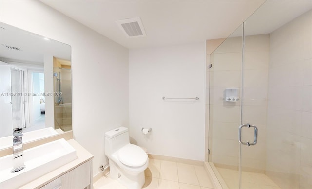 bathroom featuring vanity, tile flooring, a shower with shower door, and toilet