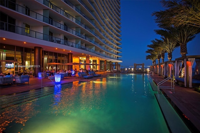 view of pool at twilight