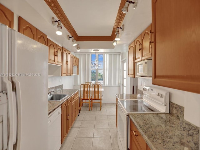 kitchen featuring track lighting, light stone counters, white appliances, light tile floors, and sink