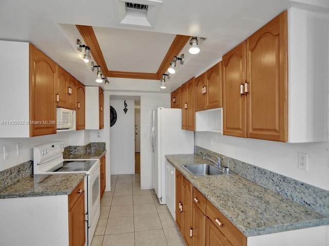 kitchen with rail lighting, white appliances, sink, and light stone counters