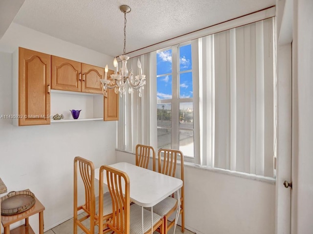 dining room with an inviting chandelier and a textured ceiling