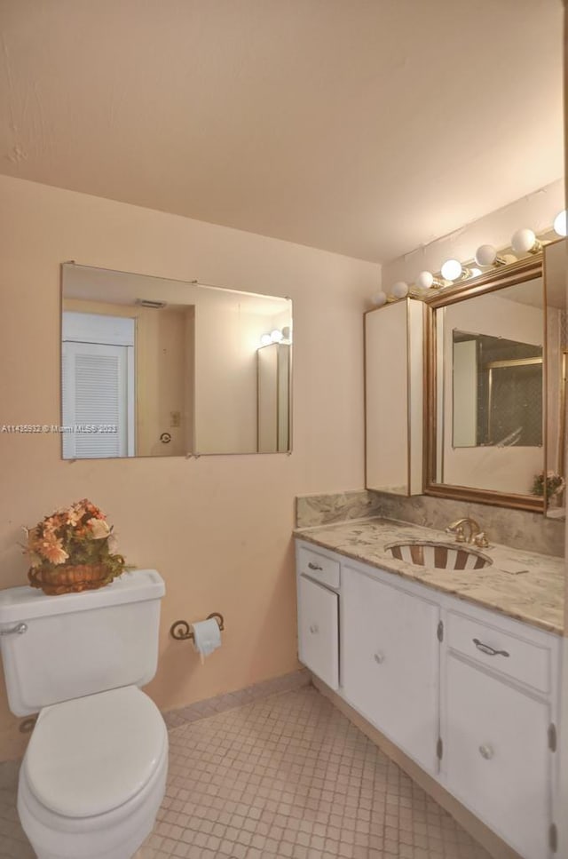 bathroom with vanity, tile floors, and toilet