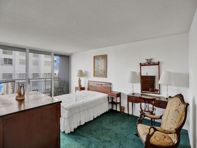 bedroom featuring access to exterior, dark carpet, and a textured ceiling