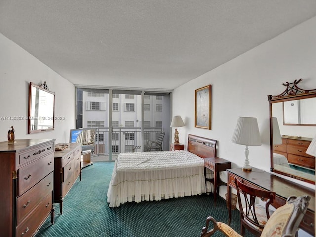 bedroom with a textured ceiling, access to outside, a wall of windows, and dark colored carpet