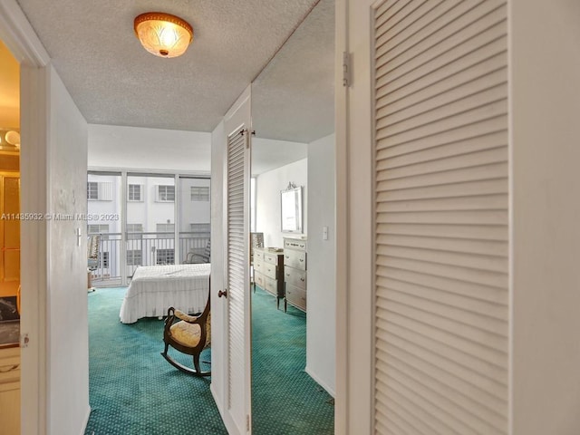 hallway featuring a textured ceiling, dark carpet, and a healthy amount of sunlight