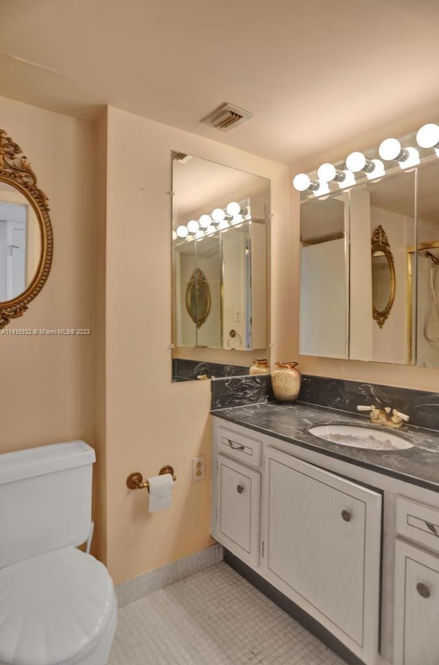 bathroom featuring tile floors, toilet, and vanity