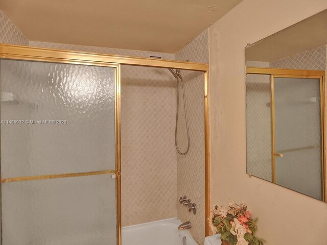 bathroom featuring combined bath / shower with glass door