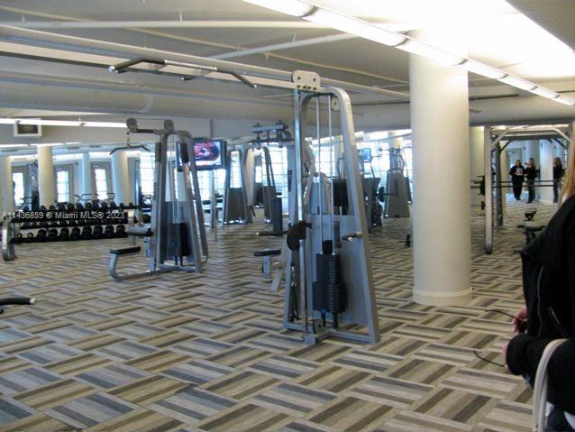 workout area with plenty of natural light and dark colored carpet