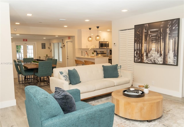 living room with french doors and light hardwood / wood-style flooring