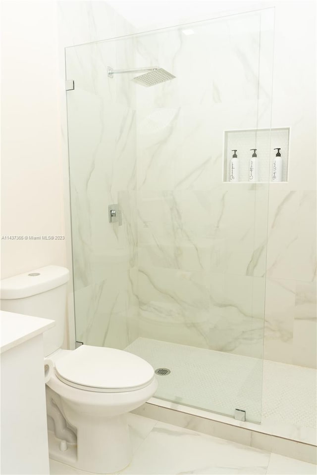 bathroom with toilet, vanity, a shower with door, and tile flooring