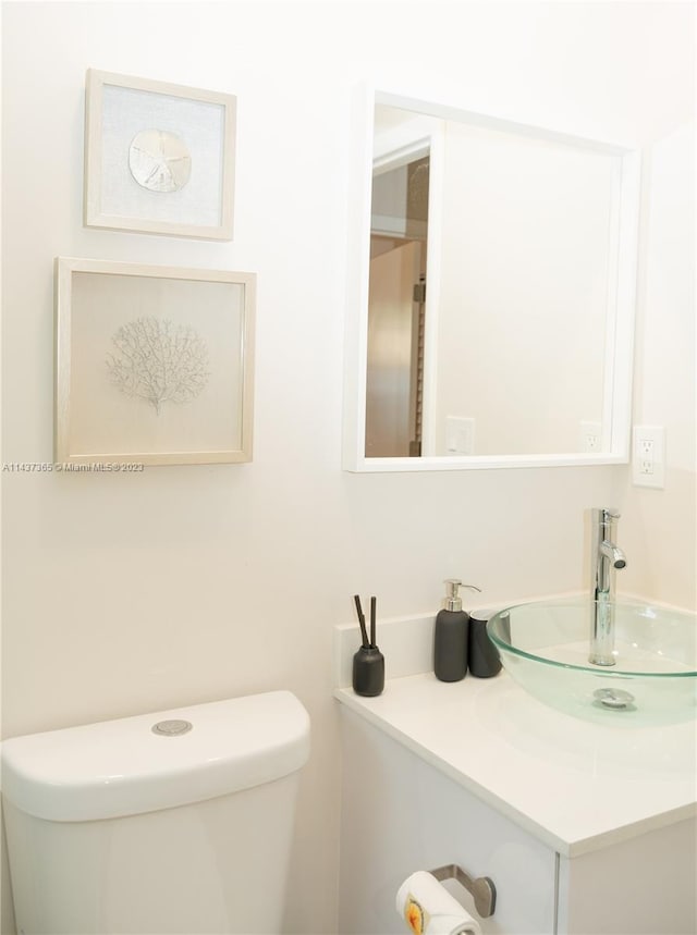 bathroom with toilet and vanity with extensive cabinet space