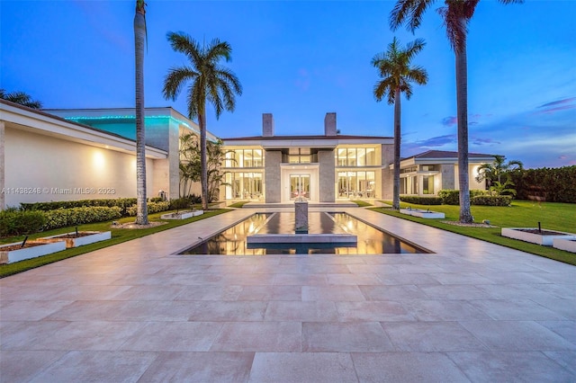 pool at dusk with a patio