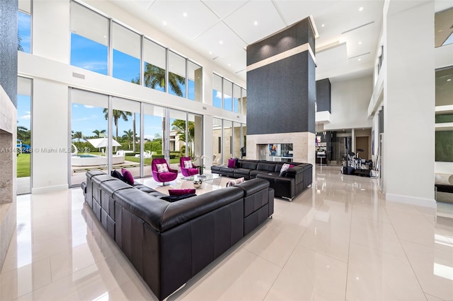 tiled living room with a towering ceiling and a fireplace