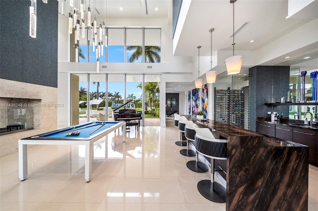 game room with light tile floors, a towering ceiling, pool table, and sink