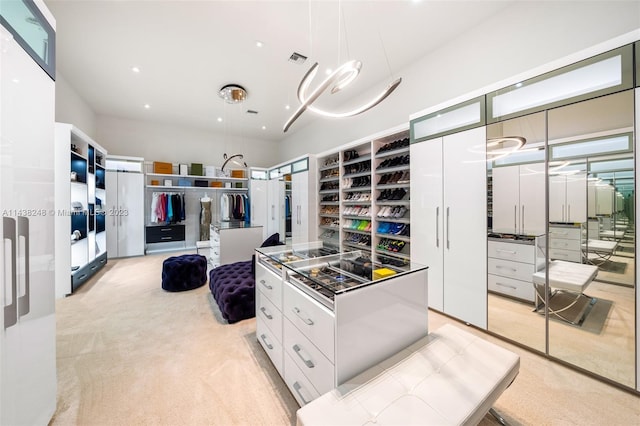 kitchen featuring pendant lighting, a kitchen island, white cabinets, and light carpet