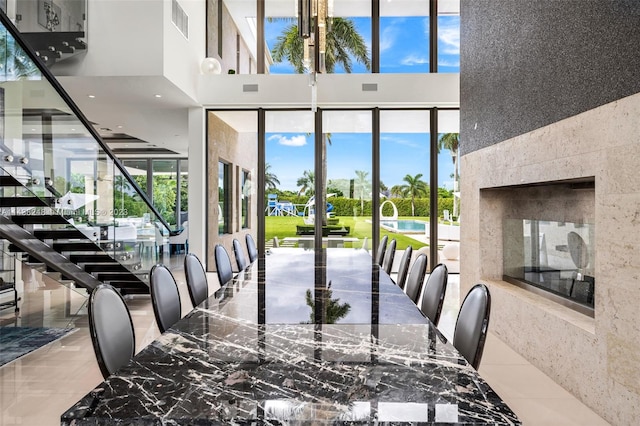 dining area featuring light tile flooring and a towering ceiling