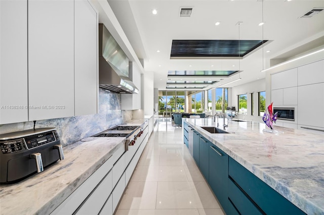 kitchen featuring white cabinetry, light tile flooring, sink, light stone counters, and tasteful backsplash