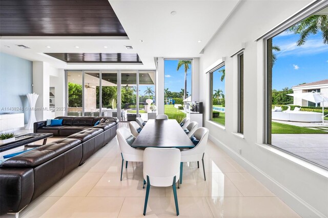 tiled dining room featuring a raised ceiling and french doors