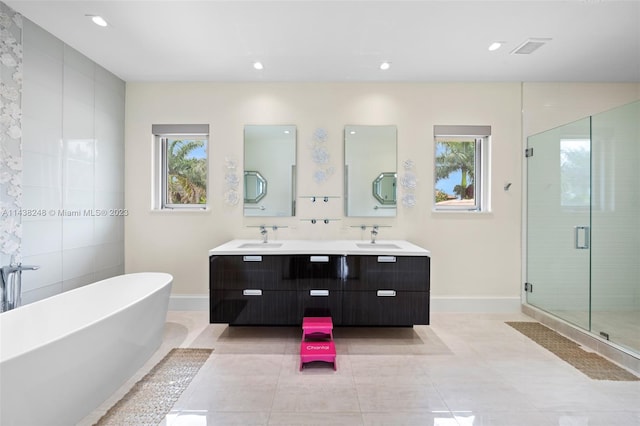 bathroom featuring a healthy amount of sunlight, tile floors, double sink, and large vanity