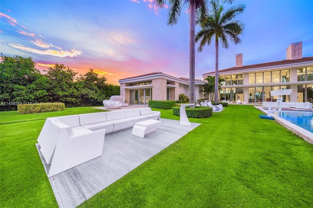 yard at dusk featuring a patio area and outdoor lounge area