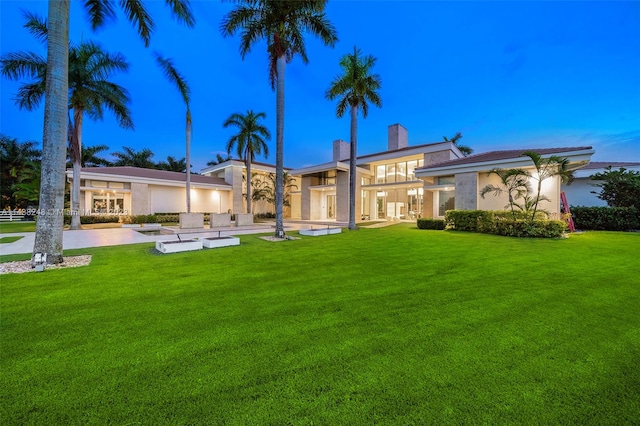 back of property featuring a lawn and a patio area