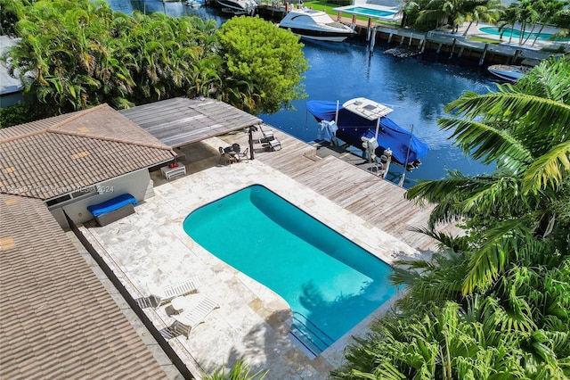 view of swimming pool featuring a boat dock and a water view