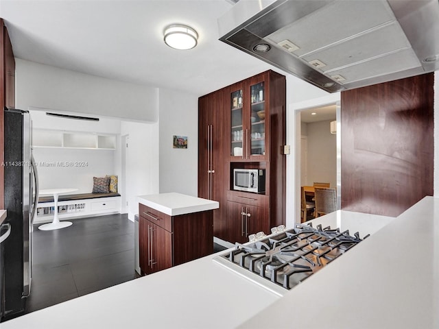 kitchen featuring a center island, range hood, and appliances with stainless steel finishes