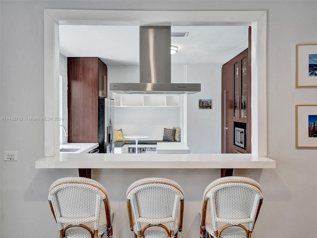 kitchen with stainless steel appliances, sink, and island exhaust hood