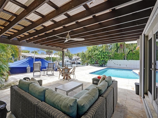 view of pool with an outdoor living space, a patio area, and ceiling fan