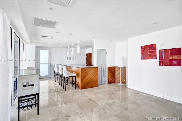 kitchen featuring a kitchen breakfast bar and light tile floors