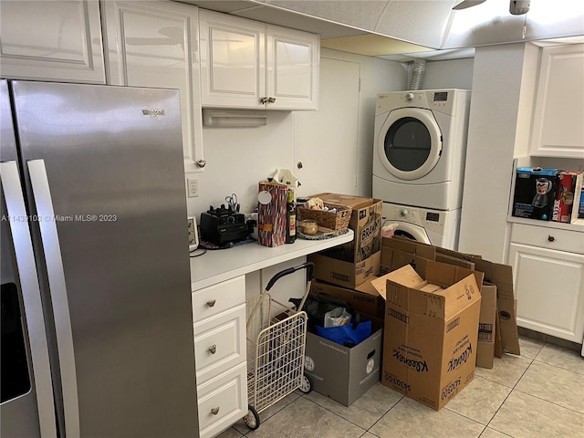 washroom featuring stacked washer / drying machine and light tile floors