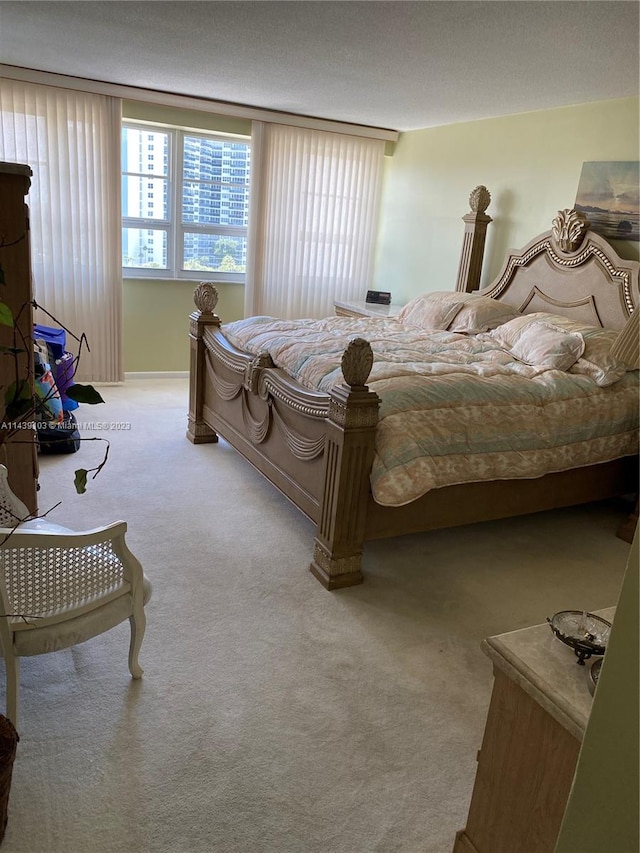 bedroom with a textured ceiling and light colored carpet