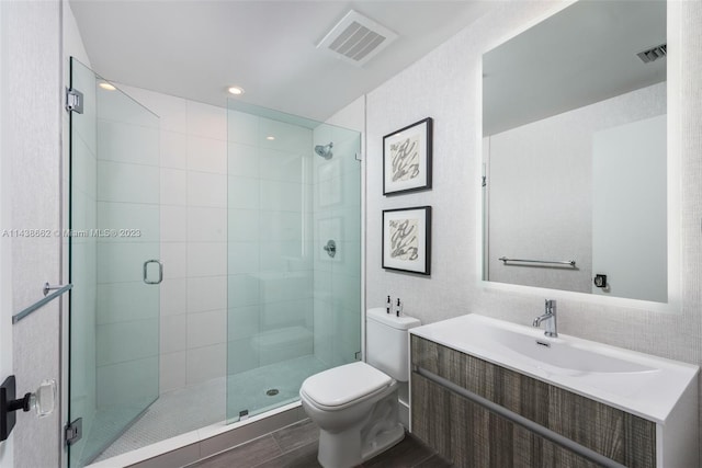 bathroom with toilet, an enclosed shower, and vanity