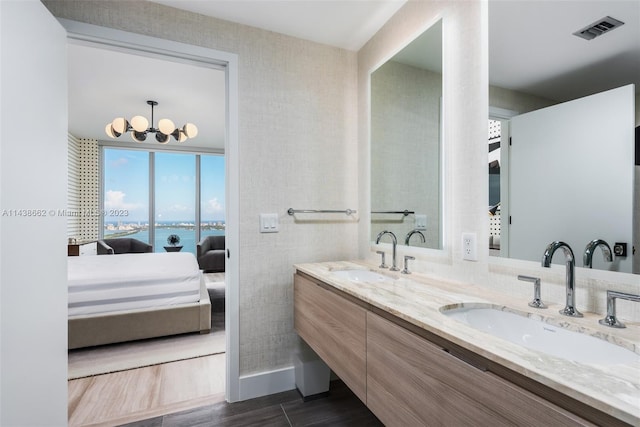 bathroom with a water view, dual bowl vanity, tile flooring, and an inviting chandelier