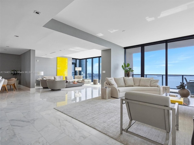 living room featuring expansive windows, marble finish floor, and a water view