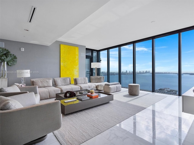 living area featuring expansive windows, marble finish floor, and a water view