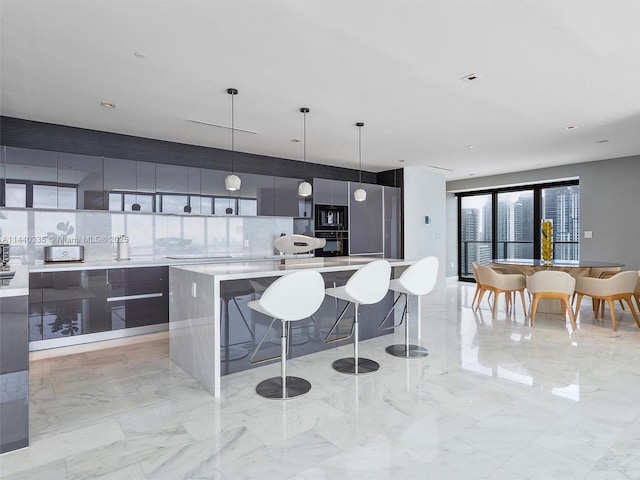 kitchen with a spacious island, modern cabinets, light countertops, and decorative light fixtures