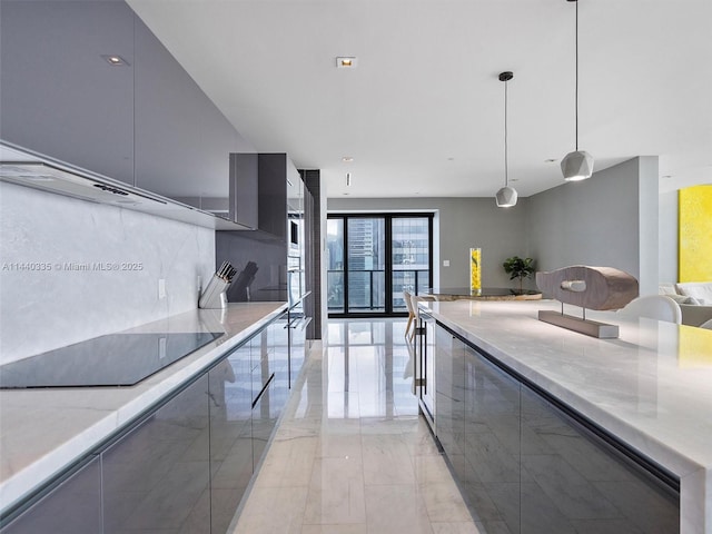 kitchen featuring modern cabinets, open floor plan, decorative light fixtures, marble finish floor, and black electric cooktop