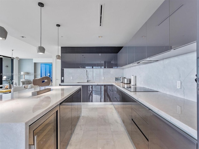 kitchen featuring black electric stovetop, modern cabinets, and decorative light fixtures