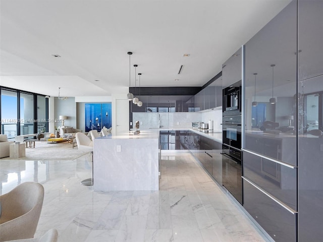 kitchen featuring decorative light fixtures, light countertops, open floor plan, modern cabinets, and oven