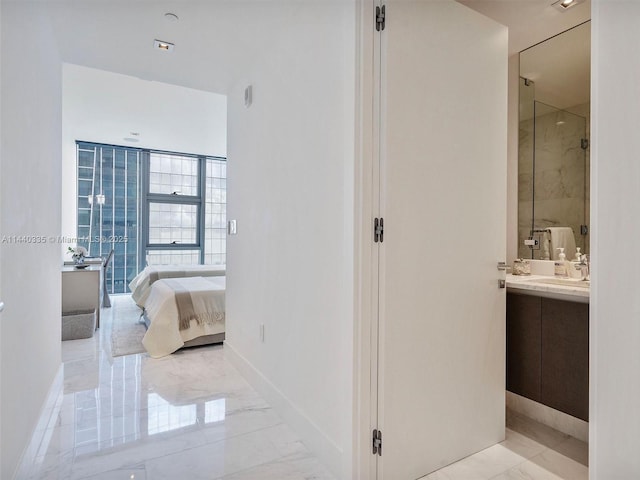 ensuite bathroom featuring marble finish floor, vanity, ensuite bath, a shower stall, and baseboards