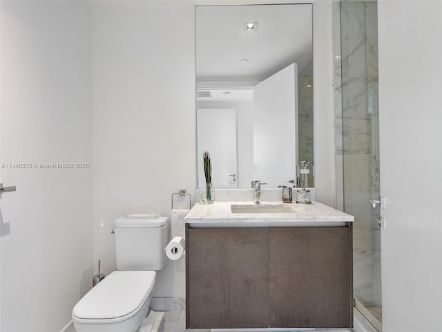 bathroom with a marble finish shower, vanity, and toilet