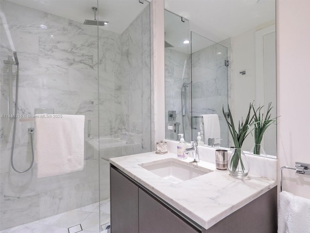 bathroom featuring a marble finish shower, vanity, and recessed lighting