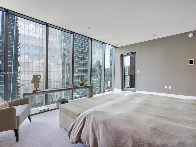 bedroom with expansive windows, baseboards, and a city view