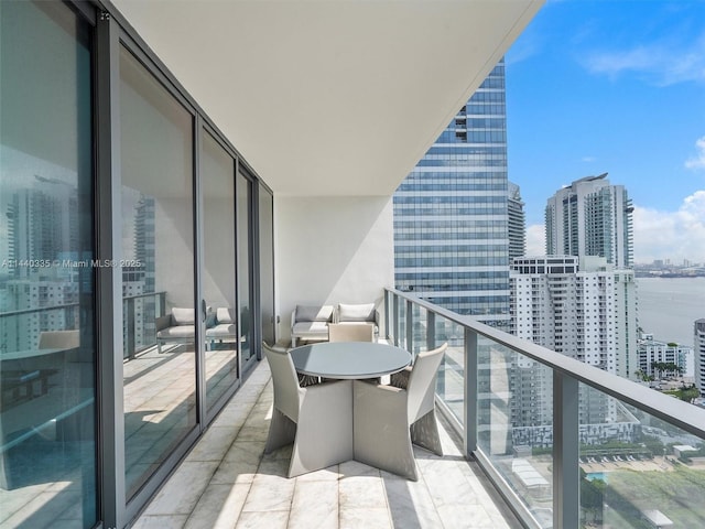 balcony featuring a water view and a city view