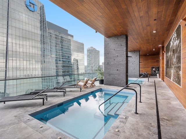 community pool with a city view and a patio