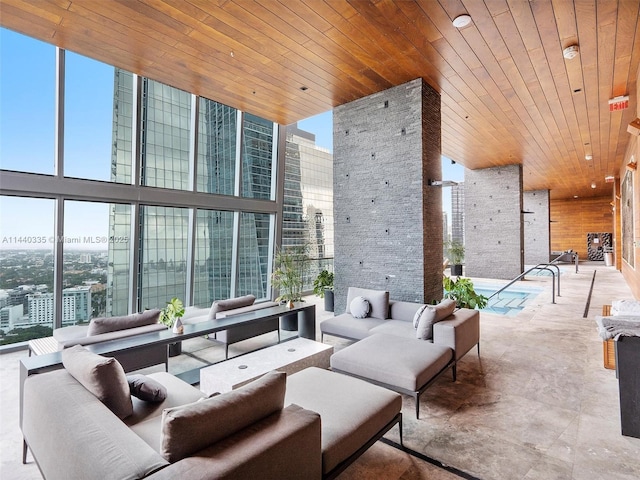 living area with a high ceiling, wooden ceiling, a view of city, and floor to ceiling windows