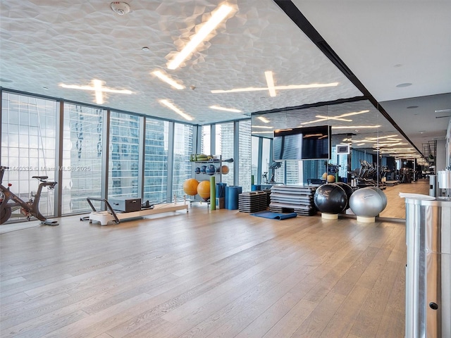 gym featuring a wall of windows and wood finished floors